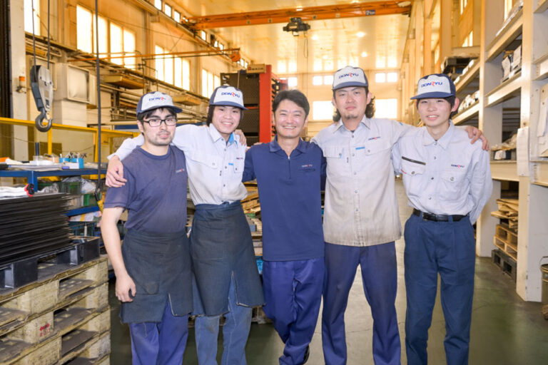 肩を組む笑顔の社員五名